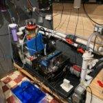 Aquarium filtration system with pipes and equipment.